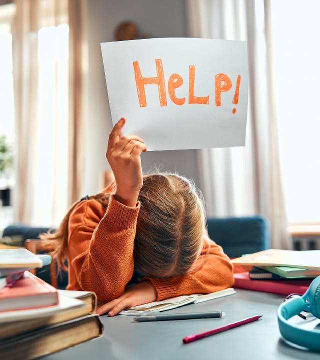 Overloaded childhood. Unknown child asking for help with inscription on paper sheet while struggling with homework