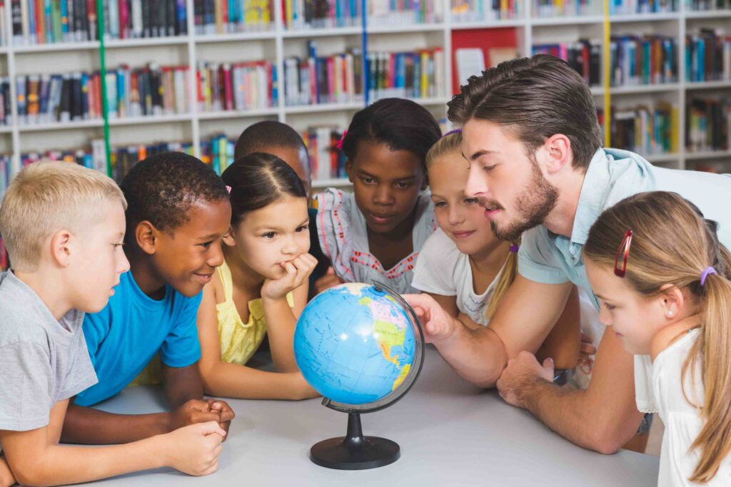 Group of students and teacher gathered around globe