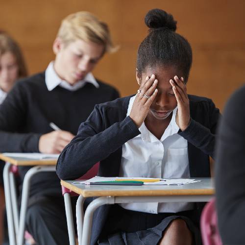 Anxious Teenage Student Sitting Examination In School Hall