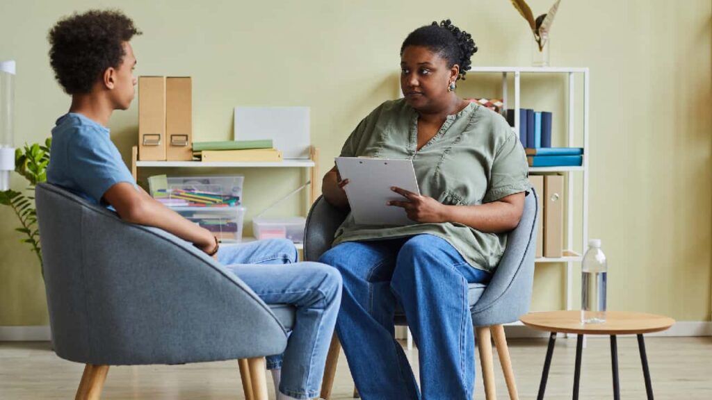 Black female teacher discussing safeguarding training with a colleague